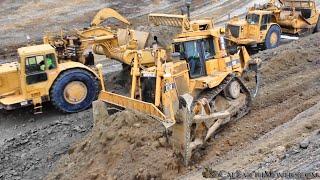 Cutting through hills with CAT 657 Scrapers to build a new roadway