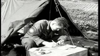 US Corporal Roger Mohr fills out report of mission in front of a tent near Kumwha...HD Stock Footage