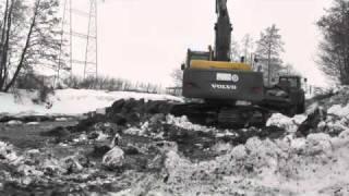 Excavator. Volvo 210 loading from a pond