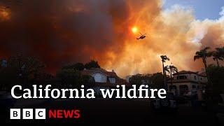 California wildfire rips through LA suburbs as 30,000 told to evacuate | BBC News