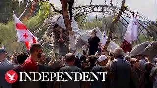 Anti-LGBT protesters burn flags and tear down float as they storm Georgia’s Pride parade