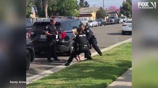 Police officers stop fellow officer punching handcuffed woman during arrest