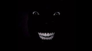 Black man smiles laughing in dark