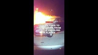 Officer tries to free woman from vehicle engulfed in flames
