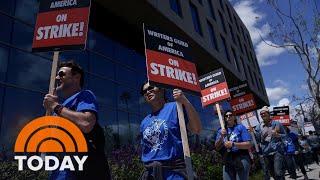 Reruns and cancellations begin as striking WGA writers picket