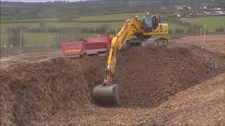 Komatsu PC490 excavator loading trucks on a road construction site