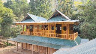 Spray painting the second floor of a wooden house - building a wooden house in the forest