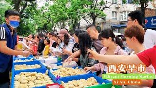 中国西安古城墙下的热闹早市，登峰造极的碳水美食，一元三个的水煎包个头真大，酸爽开胃的浆水搅团令人垂涎，健康美味的菜团菜卷供不应求，人潮涌动的早市烟火气息爆棚