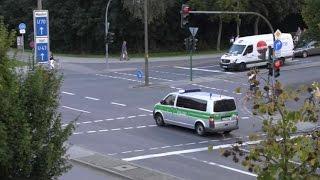 German police cars rushing through red light intersection / slowly w/o siren