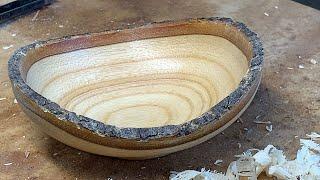 Richard Raffan turns a firewood scrap of bone-dry claret ash into a bark-rimmed bowl.