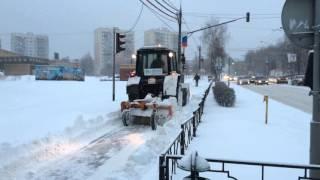 Трактор чистит от снега тротуар на Советской улице