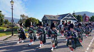 Pipe Band lead the Braemar Royal Highland Society on the march to 2024 Braemar Gathering in Scotland