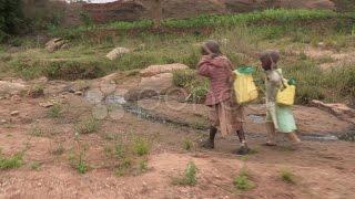 Kenya: Children Walk Home with Water. Stock Footage